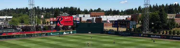 Evergreens beyond outfield of Tacoma's Cheney Stadium