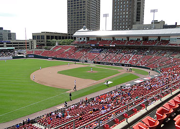 Red seats fill the ballpark that has a great big city backdrop