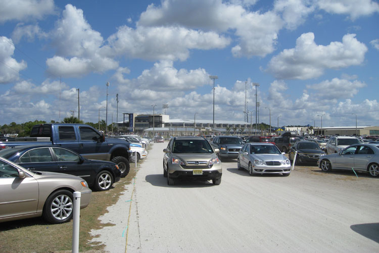 The parking lot is a grass field with a gravel entrance