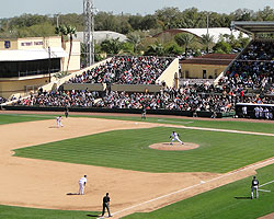 Box seats in the oddly-shaped grandstand that extends down the first base line are protected by a protective screen